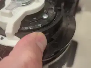 This step and the following steps are easiest if the machine lid is closed.