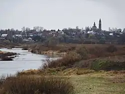 The town photographed from afar with a river nearby.