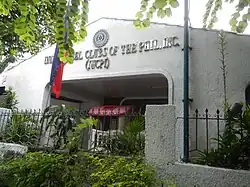 Stucco building behind with lettering reading "Inner Wheel Clubs of the Phil. (IWCPI)"