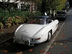 A hard-top roadster parked on a street