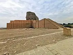 A large, partially restored, brick building with a soldier in front