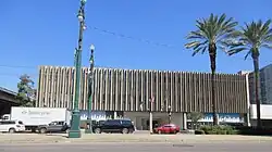 A three-story office building with a ribbed pattern and small windows on the second and third floors