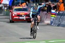 Remco Evenepoel rides a time-trial bicycle, wearing a jersey which displays the flag of Belgium