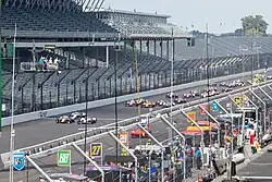 The Indy 500 field takes the green flag in front of empty grandstands.