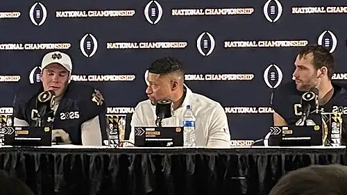 Football players and coaches giving a press conference