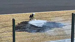 Fire marshal extinguishes a grass fire during qualifying for the 2025 Japanese Grand Prix