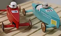 A closeup of two miniature Soap Box Derby models created by Derby historian and author Ron Reed