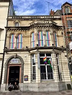 Terraced building with LGBTQ+ flags and sign 'Mary's'