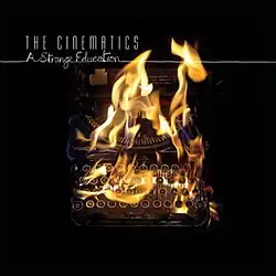 Picture of a typewriter on fire over a black square, with artist and album title in top left corner.