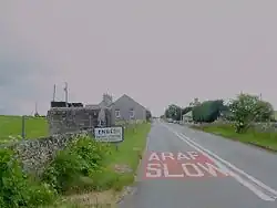 Picture of a Hamlet, taken on the road facing the village; signpost reading "Engedi"