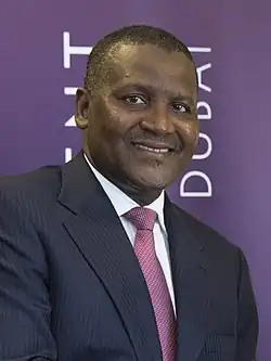 A photograph of Dangote, wearing a black suit on a white shirt and tie