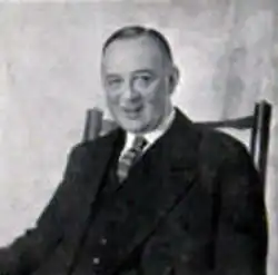 middle-aged white man with neat moustache and receding hair