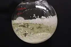 Colorless crystals forming in a 100 mL roundbottom flask