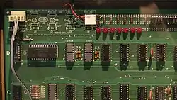 A close-up of the top-left portion of the Apple I motherboard. The chips are arranged in a grid. One chip is larger than the rest and is placed horizontally rather than vertically.
