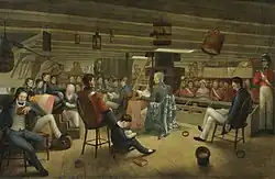 A painting showing the lower deck of a frigate; crew members wearing either blue or red uniforms are sat around the open space, with the captain sat at a table in the centre reading from a book