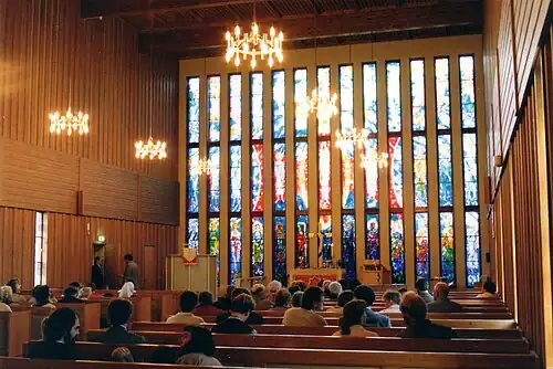 Inside Båtsfjord Church, facing the altar and the stained glass church windows.