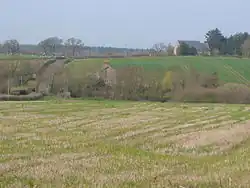 A few buildings scattered among fields and trees.