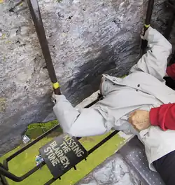 one person helps another kiss the Blarney Stone