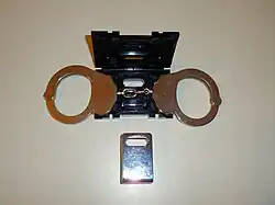 The handcuffs are put into the plastic box.