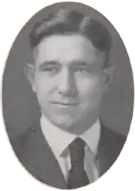 A young man facing camera wearing a suit coat and tie