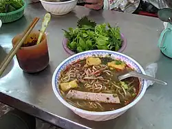 A bowl of bún ốc at a street food stall