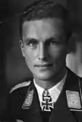 A man wearing a military uniform with an Iron Cross displayed at the front of his uniform collar.