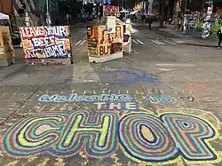 "Welcome to the CHOP" painted on a street, with additional signs