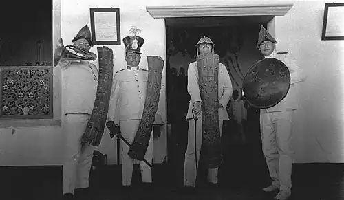 Prof.Rodenwalt and Dr.de Wolf with traditional arms posing in front of the house of the Sultan of Ternate
