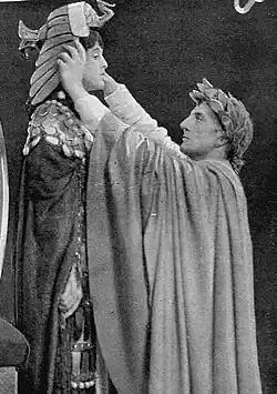 middle aged man in Ancient Roman costume placing Egyptian pharaoh's crown on a young woman