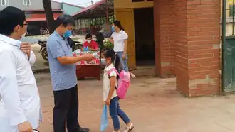 Elementary-school girl having her temperature checked outside a school