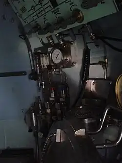 View looking into a closed bell through the side hatch showing a number of gauges and valves.