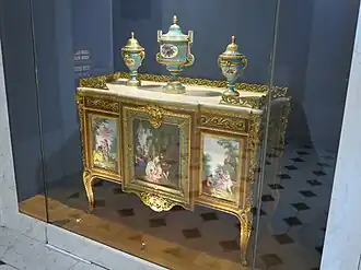 Commode of Madame du Barry; by Martin Carlin (attribution); 1772; oak base veneered with pearwood, rosewood and amaranth, soft-paste Sèvres porcelain, bronze gilt, white marble; 87 x 119 cm; Louvre[66]