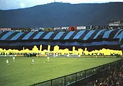 Choreography, including a large black-and-blue striped flag, on display at the Curva Nord during an Atalanta match
