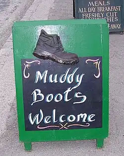 Sign in English saying "Muddy Boots Welcome"