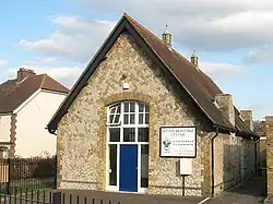 A photograph of small stone building with a v-shaped roof