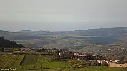 Pale skies with a village and mountains.