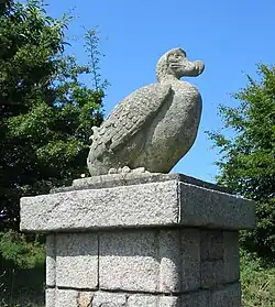 A statue of a dodo on top of a gatepost