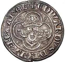 Silver coin showing a crude depiction of a man's face