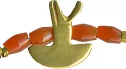 Egyptian necklace with biconical carnelian beads, rolled strips of sheet gold, and ten amulets.[19] The Walters Art Museum, Baltimore.