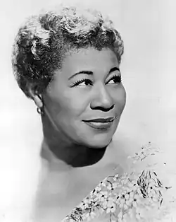 Ella Fitzgerald looking to her left while slightly smiling. The black and white image features a completely white background.