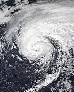 Satellite picture of Epsilon as a weakening Category 1 hurricane, with Bermuda visible to the southwest of the storm