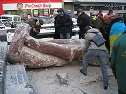 Toppled Lenin statue being broken into pieces for souvenirs