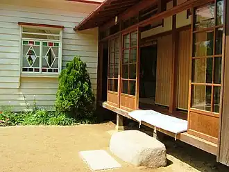 Cushions on an engawa protected by sliding glass doors. Note fume-ishi, stone step.