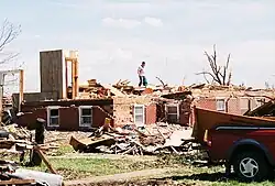 A few parts of affected buildings are left standing. Well-built structures lose all outer and some inner walls. Unanchored homes are swept away, and homes with poor anchoring may collapse entirely. Trains and train cars are all overturned. Small vehicles and similarly sized objects are lifted off the ground and tossed as projectiles. Wooded areas suffer an almost total loss of vegetation and some tree debarking may occur.