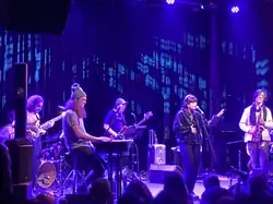 Five musicians performing on a stage