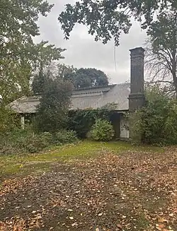 exterior of buff bricked building, in amongst foliage