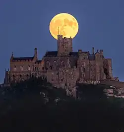 A striking photograph of the full moon rising directly above the historic castle atop St Michael's Mount, Cornwall, England. Photograph By Ben Hawkins Photography