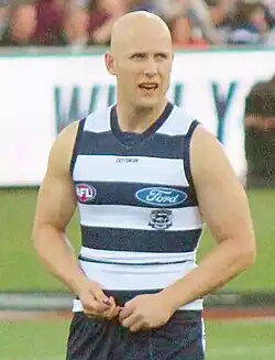 Baldheaded male athlete during an Australian rules football game
