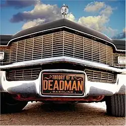 A photo of a car driving near a road with clouds and a trophy above it with a brown sign that reads "Theory of a Deadman - Gasoline".