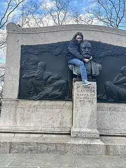 girl climbs statue of Gaynor
